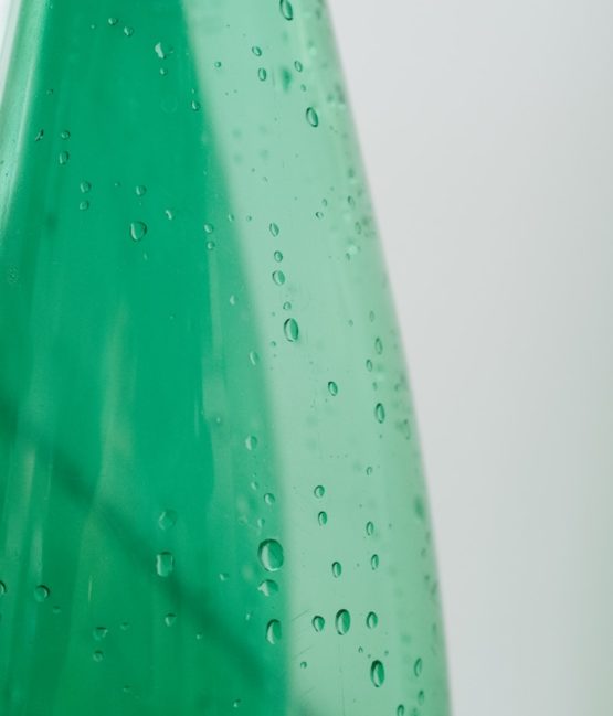 green plastic bottle with water droplets